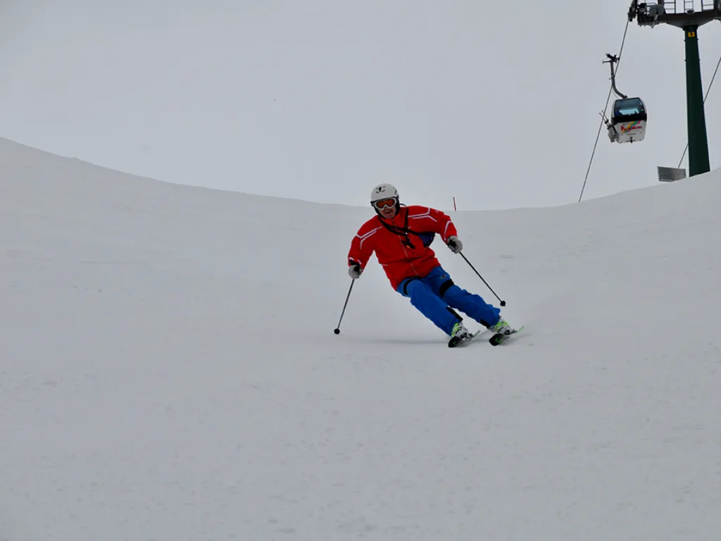 Skifahrer zieht einen Schwung auf dem freien Hang.